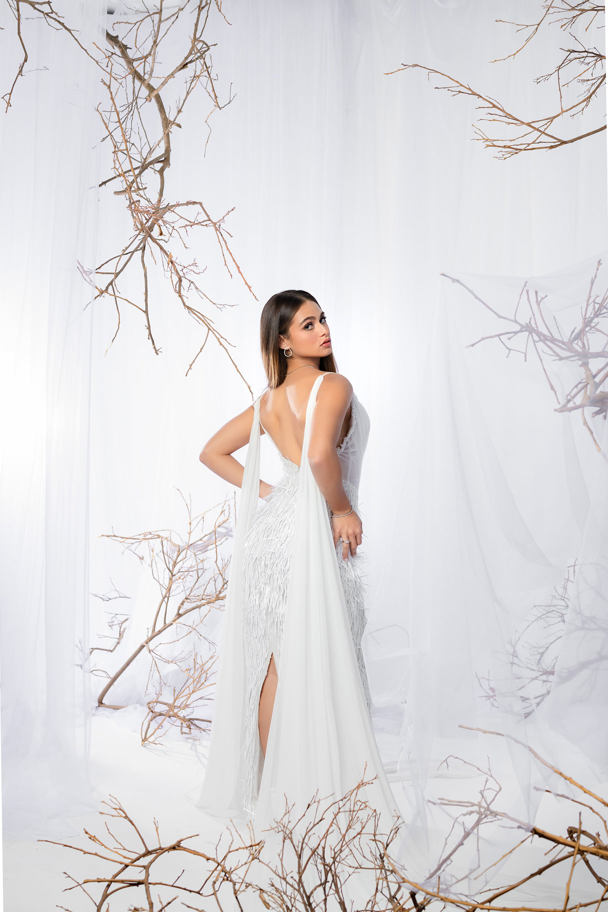 Ivory Mirage Dress a graceful white gown layered in sheer tulle over a texture fringed skirt.