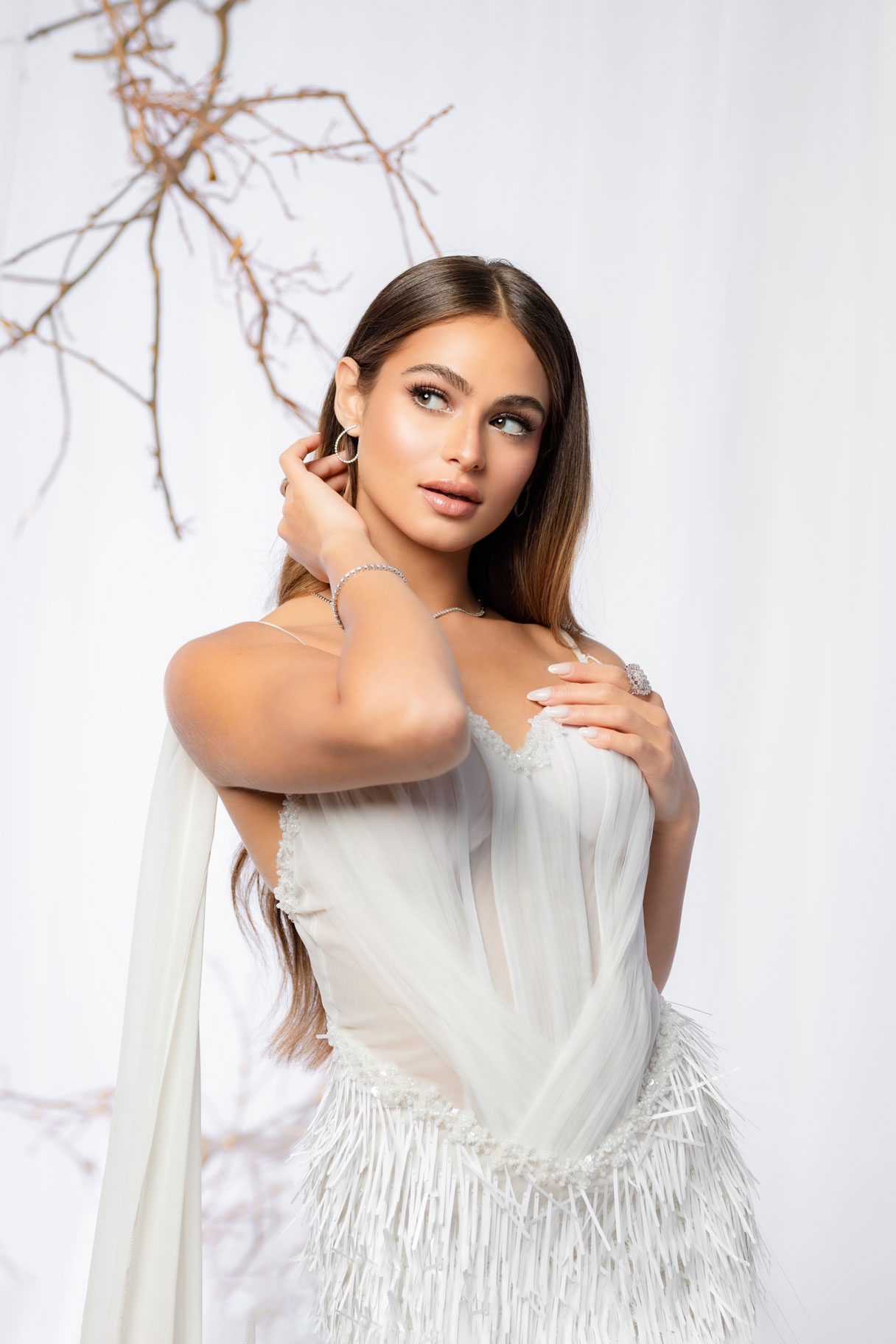 Ivory Mirage Dress a graceful white gown layered in sheer tulle over a texture fringed skirt.